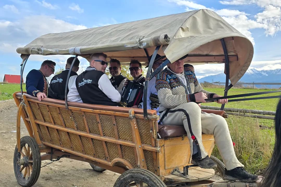 Drewniany wóz regionalny z grupą gości, w tle Tatry